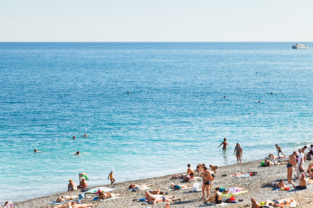 YALTA, RUSSIA - SEPTEMBER 30, 2014: people sunbathing on pebble beach and swimming in Black Sea in Yalta, Crimea. Yalta is resort city on the north coast of the Black Sea on the Crimean peninsula.のeditorial素材