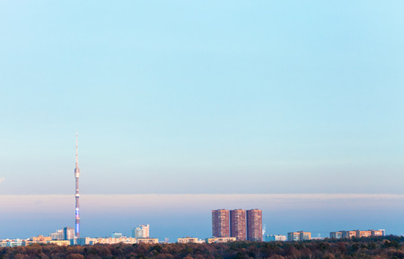 evening blue sky over urban houses and TV tower in autumnの写真素材