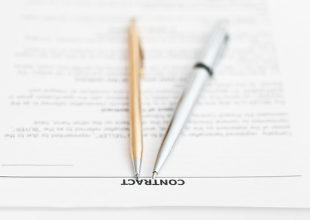 pages of sales agreement and two pens close upの写真素材