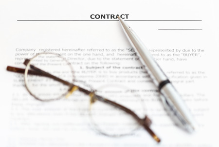 silver pen and eyeglasses on page of sales agreementの写真素材