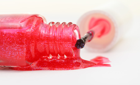 bottle with spilled pink nail polish close up on white backgroundの写真素材