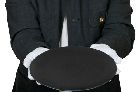 above view of empty black plate in hands in white gloves isolated on white backgroundの写真素材