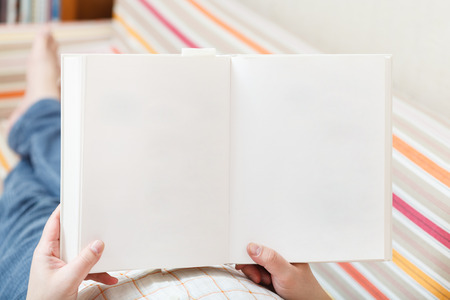 man read book with empty pages in living roomの写真素材