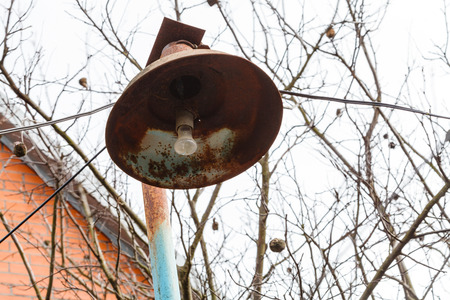 rusty lantern with electric light bulb at village backyard in spring dayの写真素材