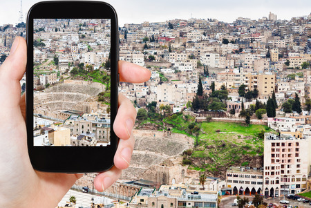travel concept - tourist taking photo of Amman city on mobile gadget, Jordanの写真素材