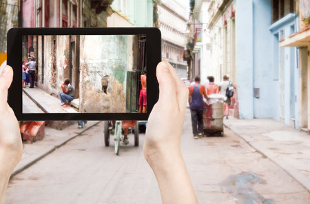 travel concept - tourist taking photo of old street in Havana on mobile gadget, Cubaの写真素材