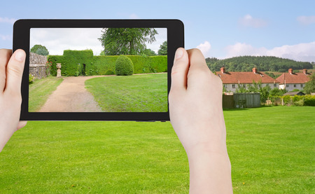 travel concept - tourist taking photo of green lawn in South England country on mobile gadgetの写真素材