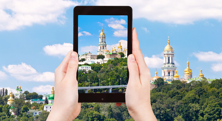 travel concept - tourist taking photo of Kiev Pechersk Lavra, Kiev, Ukraine on mobile gadgetの写真素材