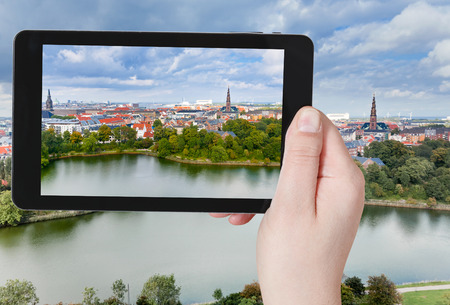travel concept - tourist taking photo of Copenhagen center on mobile gadget, Denmarkの写真素材