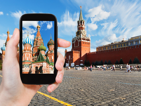 travel concept - tourist taking photo of Red Square in Moscow in summer day on mobile gadget, Russiaの写真素材