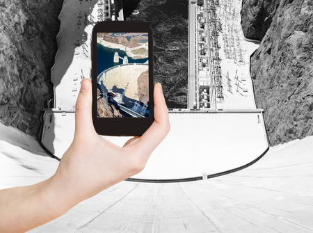 travel concept - tourist shooting photo of above view of of Hoover Dam on mobile gadget, USAの写真素材