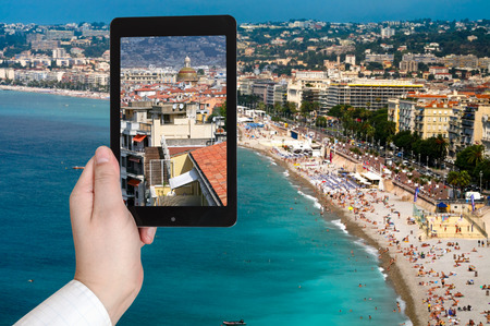 travel concept - tourist taking photo of Nice city on Azure coast, France on mobile gadgetの写真素材