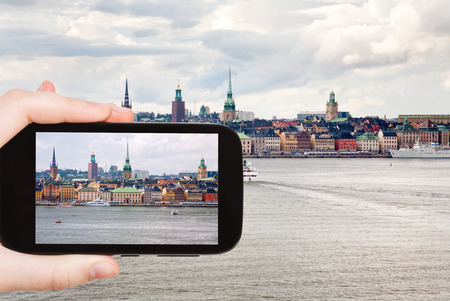 travel concept - tourist taking photo panorama of Stockholm city in autumn day, Sweden on mobile gadgetの写真素材