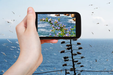 travel concept - tourist takes picture of mediterranean sea coastline in Costa Brava coast on...