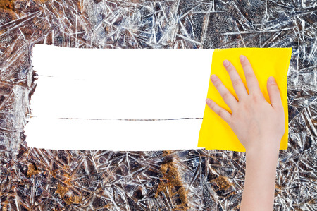 season concept - hand deletes frozen ice by yellow rag from image and white empty copy space are appearingの写真素材