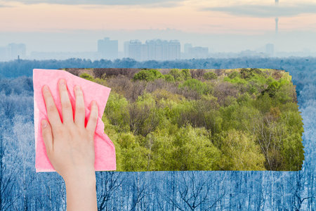 season concept - hand deletes winter frozen trees by pink cloth from image and green summer woods...
