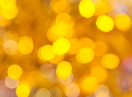 abstract blurred background - yellow shimmering Christmas lights bokeh of electric garlands on Xmas tree