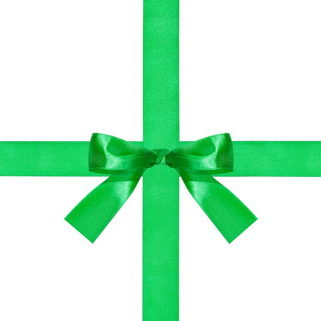 one big green bow knot on two crossing silk ribbons isolated on white backgroundの写真素材