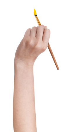 hand holds artistic paintbrush with yellow paint isolated on white backgroundの写真素材