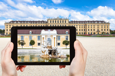 travel concept - tourist take picture of fountain near Schloss Schonbrunn palace in Vienna on tablet pvのeditorial素材
