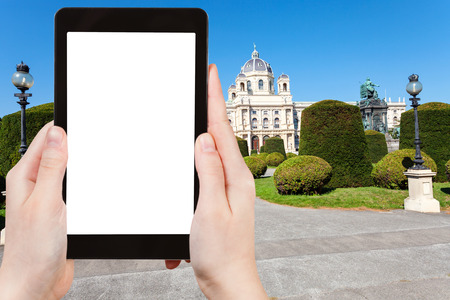 travel concept - tourist photographs Museum Natural History (Naturhistorisches) at Maria Theresien Platz in Vienna on tablet pc with cut out screen with blank place for advertising logoのeditorial素材