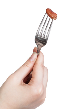 one brown bean impaled on fork in female hand isolated on white backgroundの写真素材
