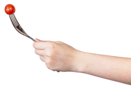 hand holds fork with impaled one fresh red cherry tomato isolated on white backgroundの写真素材