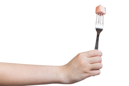 side view of fork with impaled piece of lard in hand isolated on white backgroundの写真素材