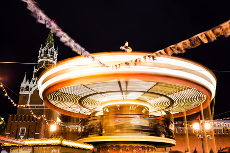 MOSCOW, RUSSIA - DECEMBER 6, 2015: Spasskaya tower of Kremlin and Merry-go-round carousel on Red Square on Moscow Christmas Fair in night. Red Square is the central historical square in Moscow.のeditorial素材