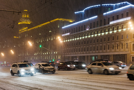 snowfall in night city - cars driving under snow on Bolshaya Sukharevskaya Square, Moscowの写真素材