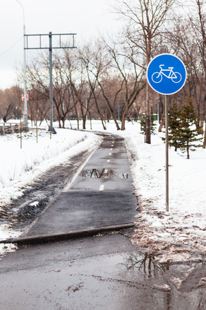 wet bicycle path in city in bad weather in early spring seasonの写真素材
