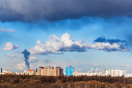 gray clouds over town and woods in sunny spring dayの写真素材