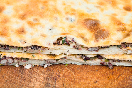 traditional georgian cuisine - cutting bean filled bread (Lobiani) close up