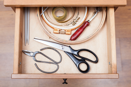 top view of accessories for embroidery in open drawer of nightstandの写真素材