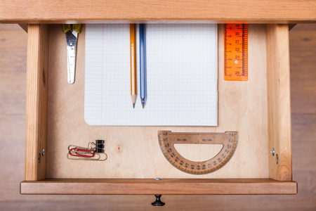 top view of school set in open drawer of nightstandの写真素材