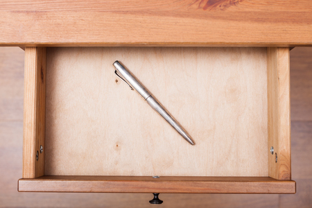 top view of old silver pen in open drawer of nightstandの写真素材