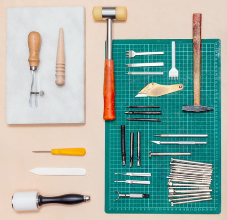 top view of various tools for leathercrafting on natural leather surface