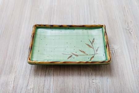 one green square plate on gray brown table