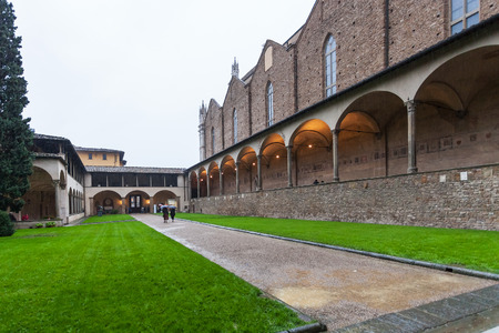 FLORENCE, ITALY - NOVEMBER 6, 2016: Arnolfo cloister of Basilica di Santa Croce (Basilica of the Holy Cross) in rain in Florence city. The church is burial place of famous Italians.のeditorial素材