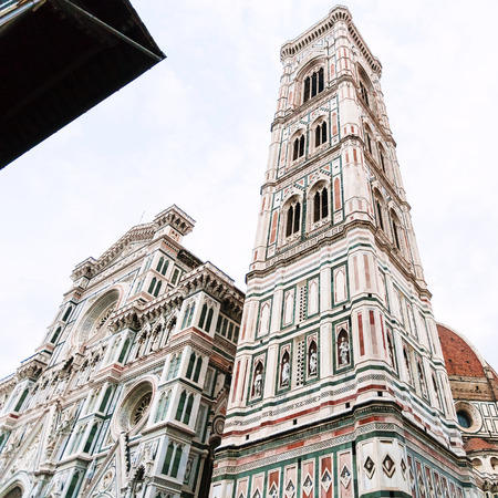 travel to Italy - facades of Giotto's Campanile and Duomo Cathedral (Cattedrale Santa Maria del Fiore, Duomo di Firenze, Cathedral of Saint Mary of the Flowers) in Florence city in morningの写真素材
