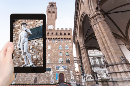 travel concept - tourist photographs David statue near palazzo vecchio in Florence city on tablet in Italyの写真素材