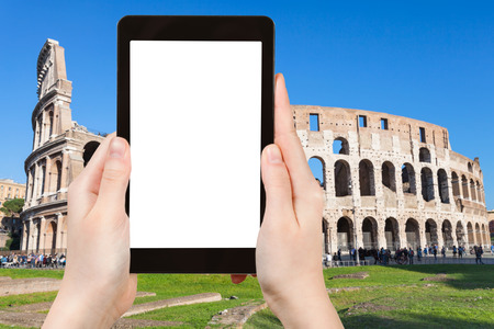 travel concept - tourist photographs Coliseum in Rome city on tablet with cut out screen with blank place for advertising in Italyの写真素材