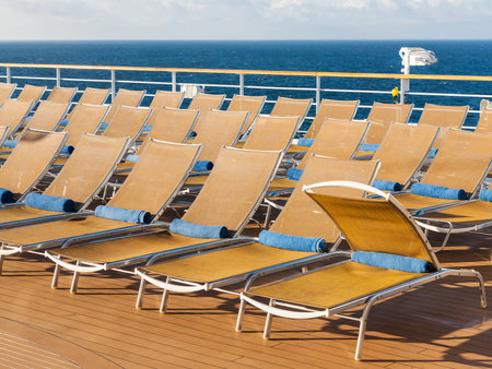 many empty chairs on outdoor deck on stern of cruise liner