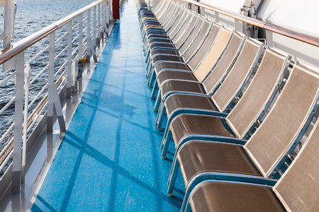 row of sunbathing chairs on deck of cruise linerの写真素材