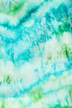 textile background - abstract blue and green pattern dyed on fabric in nodular batik technique close upの写真素材