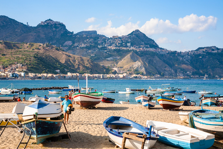 GIARDINI NAXOS, ITALY - JULY 6, 2011: people near boats on beach in Giardini Naxos town. Naxos was founded by Thucles the Chalcidian in 734 BC, and since 1970s it has become a seaside-resortのeditorial素材