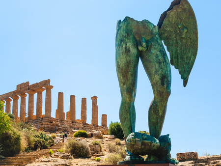 AGRIGENTO, ITALY - JUNE 29, 2011: Icarus statue and Temple of Juno in Valley of the Temples in Sicily. This area has largest and best-preserved ancient Greek buildings outside of Greece itselfのeditorial素材