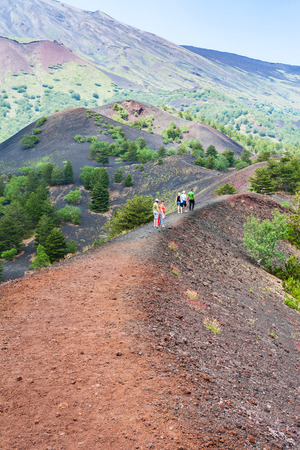 ETNA, ITALY - JULY 1, 2011 - tourists walk on path between old craters of Etna mount. Mount Etna is active volcano on the east coast of Sicily, the tallest active volcano in Europeのeditorial素材
