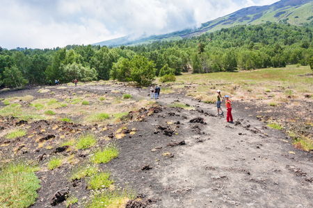 ETNA, ITALY - JULY 1, 2011 - tourists walk on path on slope of Etna mount. Mount Etna is active volcano on the east coast of Sicily, the tallest active volcano in Europeのeditorial素材
