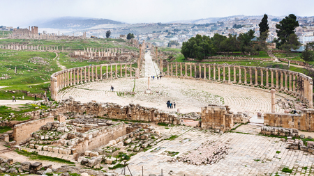 Travel to Middle East country Kingdom of Jordan - above view of The Oval Forum and Cardo Maximus path in Jerash (ancient Gerasa) town in winterの写真素材